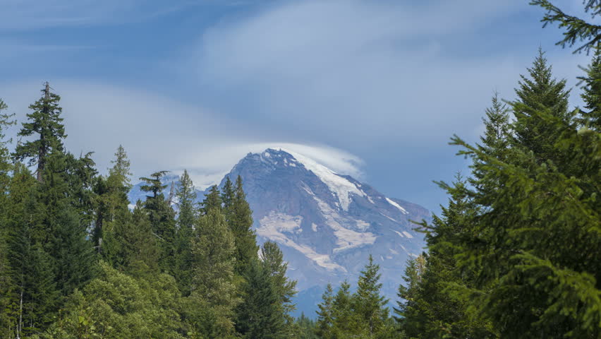 Timelapse of clouds passing the peak of Mt Rainier with trees in the foreground