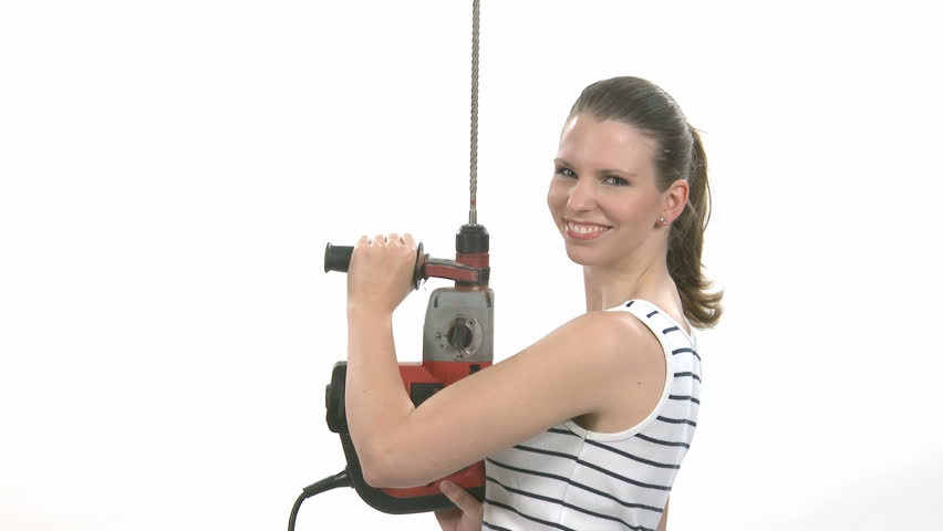 Young craftswoman with a power drill in front of white background