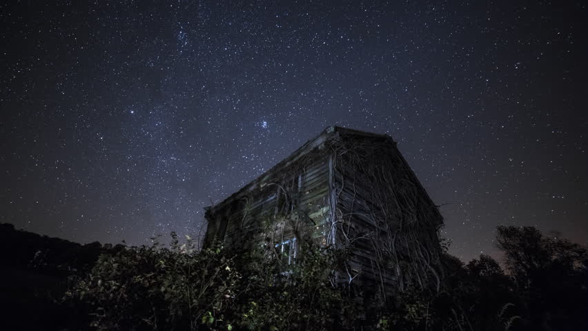 Stars above an overgrown abandoned cottage