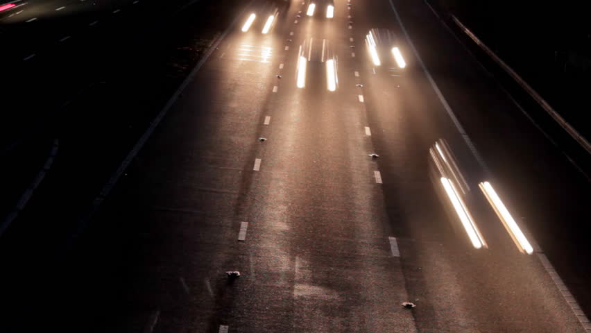 Car headlights travel toward camera, timelapse