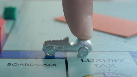 BOSTON, MA - NOV 7: Monopoly car token moving along on November 7, 2017. Over 250 million sets of Monopoly have been sold internationally making it possibly the most popular board game in the world.