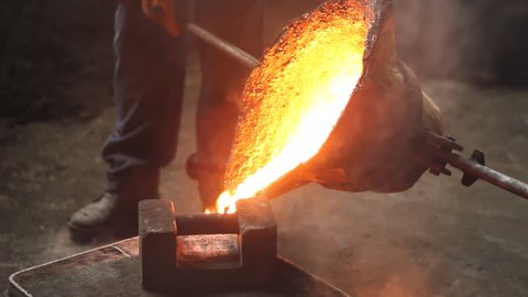 Liquid metal in the factory, foundry, smelting iron and processing, workers pouring liquid iron into molds. Iron casting