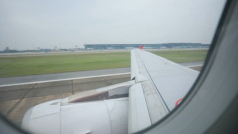 through window view of passenture plane  taking off on runway