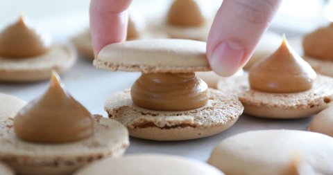 Making Caramel Macaroons : Close up shot of connecting two halves of macaroons with caramel cream