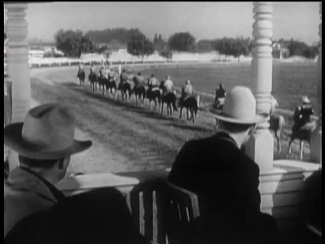 Spectators in booth watching the start of horse race