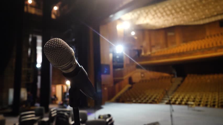 Microphone on the stage and empty hall during the rehearsal. Microphone on stage with stage-lights in the background. Microphone on the stage in the empty hall Royalty-Free Stock Footage #32571649