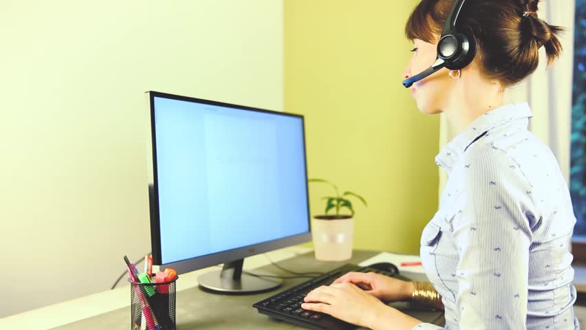 Smiling female customer service executive talking on headset at desk in office. Helpdesk, IT support concept Royalty-Free Stock Footage #32573485