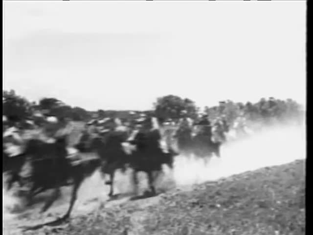 Large group of cowboys on galloping horses in a hurry