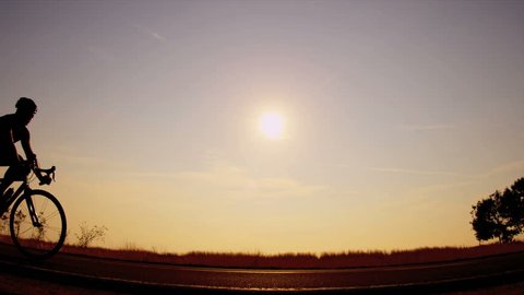 Morning silhouette male biking in the hot sun, closeup shot Stock Video