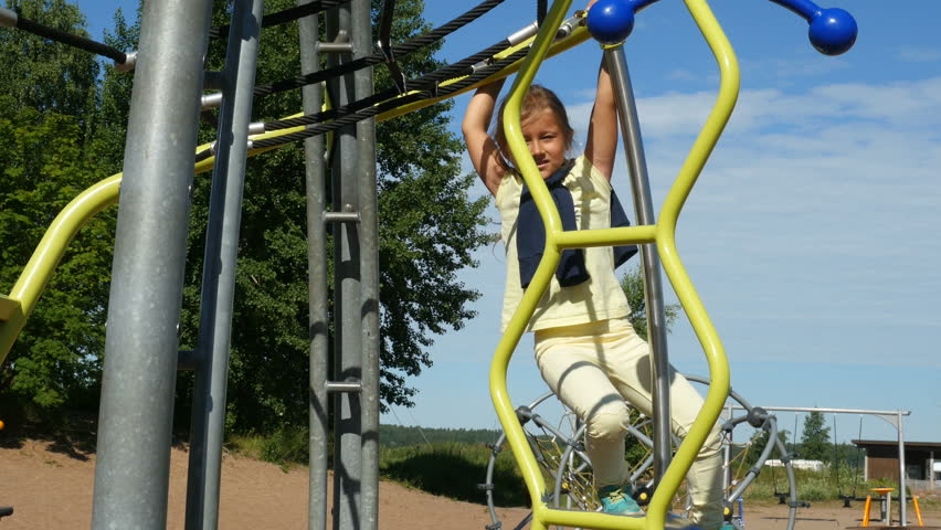 Mother walking with kids and playing on sandy playground