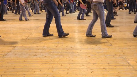 Legs moving together at American horse festival. Music tradition jeans boots and flag. People dancing cowboy line dance at a folk country event, USA style