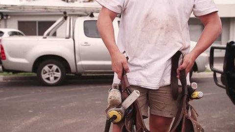 Apprentice builder puts on tool belt ready work