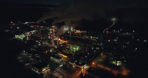 Night aerial shot of  the oil refinery. Lots of lights. Industrial areal. Big industrial area. Lots of lights. Aerial footage. Night.