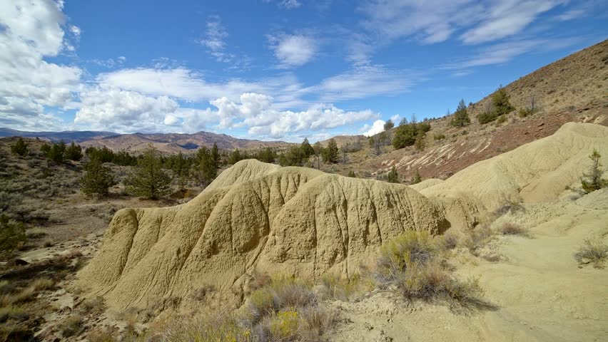 Badlands yellow clay John day fossil beds formations clouds and shadows drift over a remote desert mountain Sutton Mountain close to the Painted hills