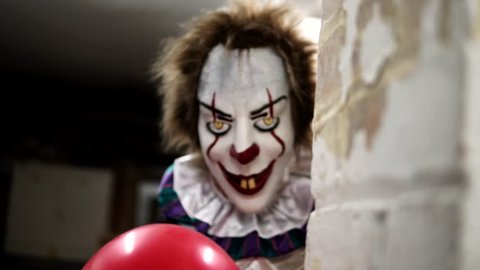Evil Clown in Dark Scary Halloween Horror Scene, Frightening with Balloon