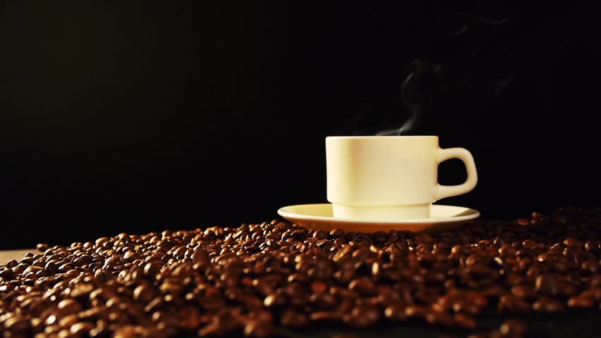cup of black hot coffee standing on the coffee beans
