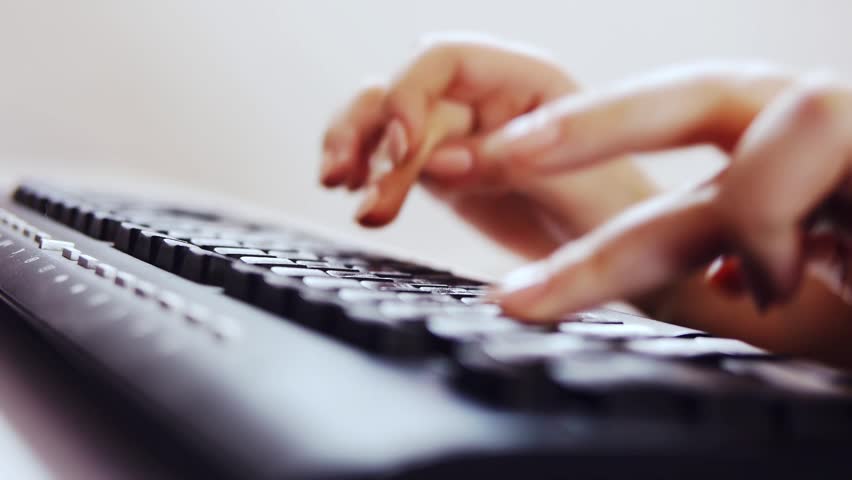 Hands of a woman typing on the keyboard