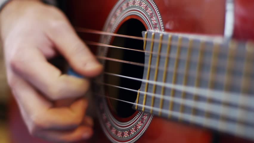 Man playing an acoustic guitar closeup