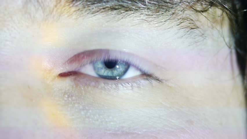 man's blue eye in the light
