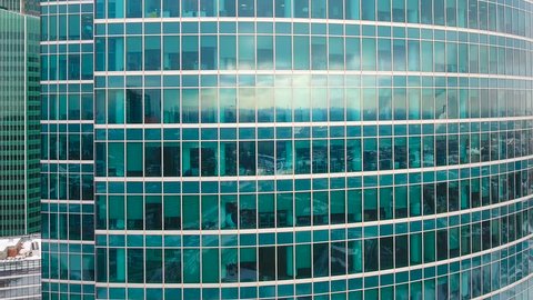 A zooming out shot on business building reflective glass walls.