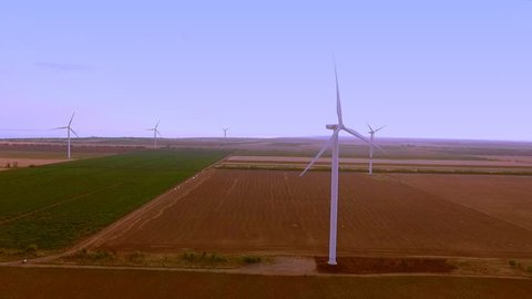 Fly over wind farm with rotating wind turbine power generators aerial video