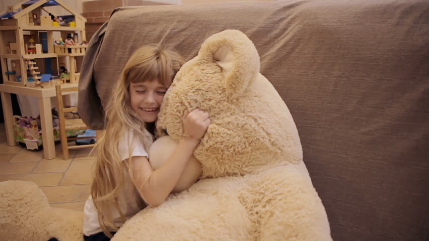 girl hugging giant teddy bear