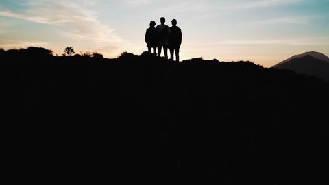 Group of Friends Standing On Top of Mount Batur in Bali Looking Out The View at Sunrise 4K