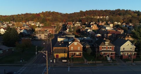 A profile moving aerial establishing shot of a typical Pennsylvania small town at sunset. Pittsburgh suburbs.  	