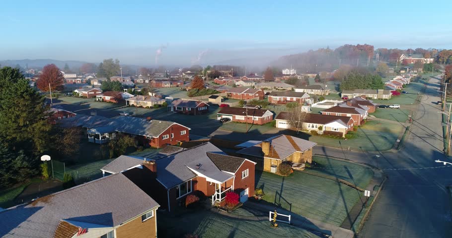 A forward rising aerial establishing shot of a typical Western Pennsylvania residential neighborhood on a frosty late-Autumn morning. Pittsburgh suburbs. Shot at 60fps.  	