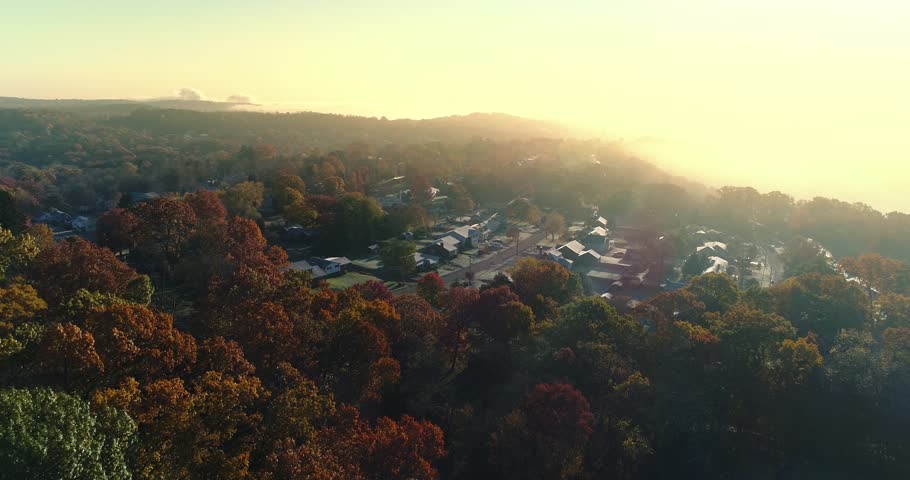 A slow forward aerial establishing shot of a typical Western Pennsylvania residential neighborhood on a foggy late-Autumn morning. Pittsburgh suburbs. Shot at 60fps.  	