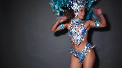 Beautiful and happy woman dancing samba while wearing traditional blue costume