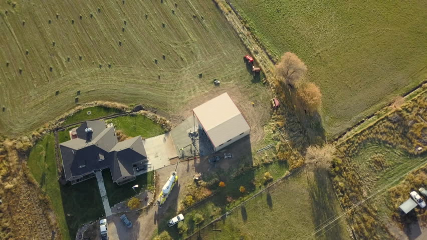 FOUNTAIN GREEN, UTAH - 25 SEP 2017: Aerial rural farm ranch new building construction circle. Construction of rural farm agriculture building. Delivery installation of prefabricated metal building.