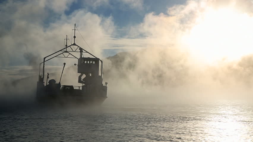 Ferry crossing fjord in sea smoke very cold weather condition