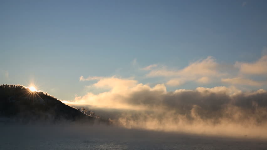 Fjord in sea smoke low sun reflections