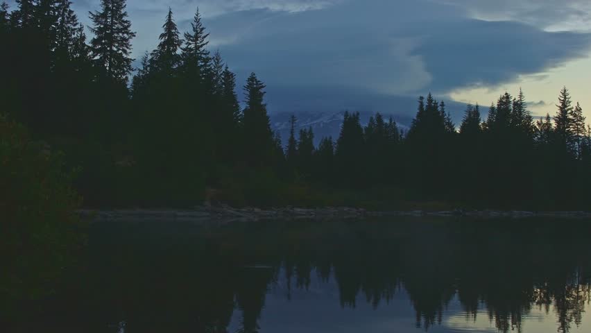 Dawn reflection of Mt. Hood covered in clouds on Mirror Lake in the fall forest
