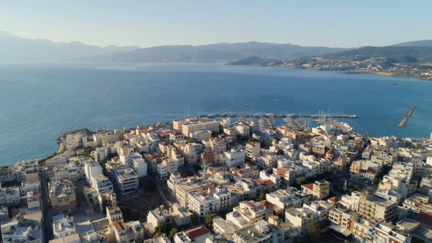 Reverse aerial view of old town streets and buildings in Agios Nikolaos, Crete, Greece