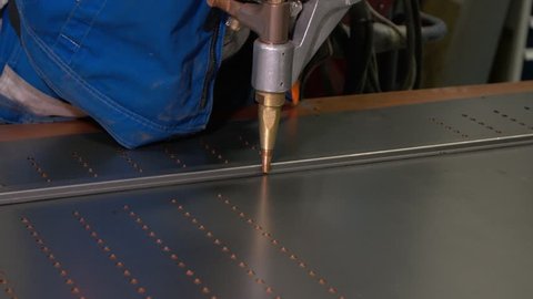 Work using mechanized hand for spot welding of metal izdeliy.Muzhchina working in a factory with a metal, its duty spot welding and soldering.