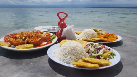 Closeup view of caribbean food served in table on the beach.