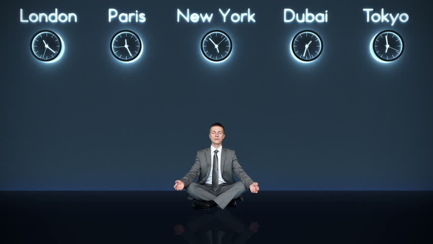 Businessman Meditating with World Clocks on Background in Dark Room