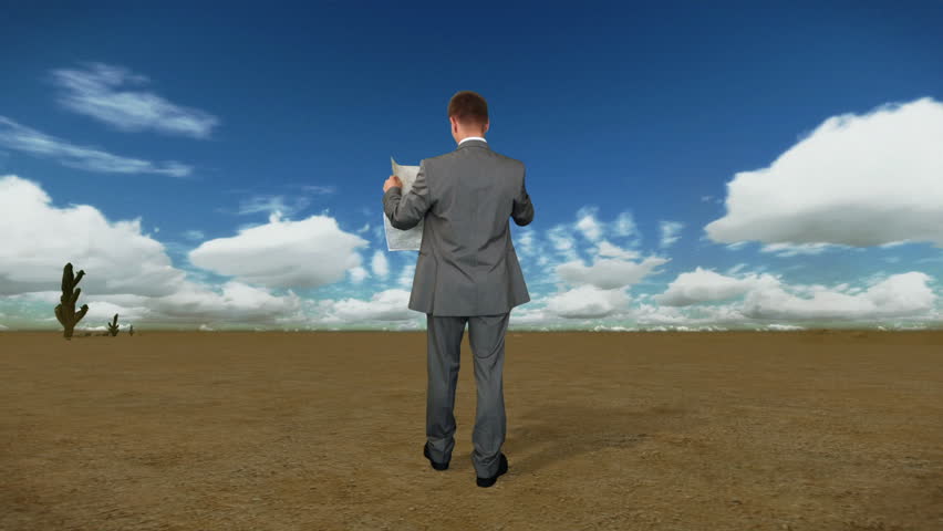 Businessman with Map in Desert with Time Lapse Clouds, back view