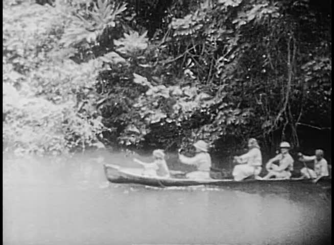 People rowing down river on canoe