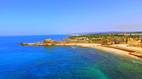 Aerial of historical, ancient, Caesarea amphitheater built in roman style of Coliseum on beach of Mediterranean sea with archeological sites in view, famous, iconic and popular tourist destination