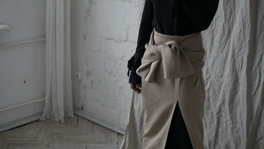 Sensual young woman wearing panties and coat and posing for camera.