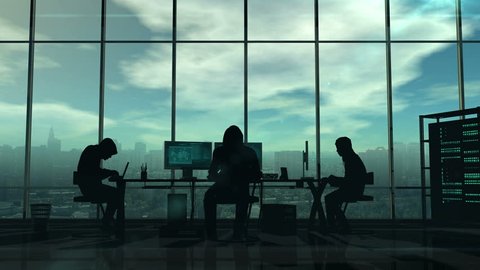 Dark silhouettes of hackers at work on a background of a gloomy city. Displays the virtual online crimes and cyber attacks.