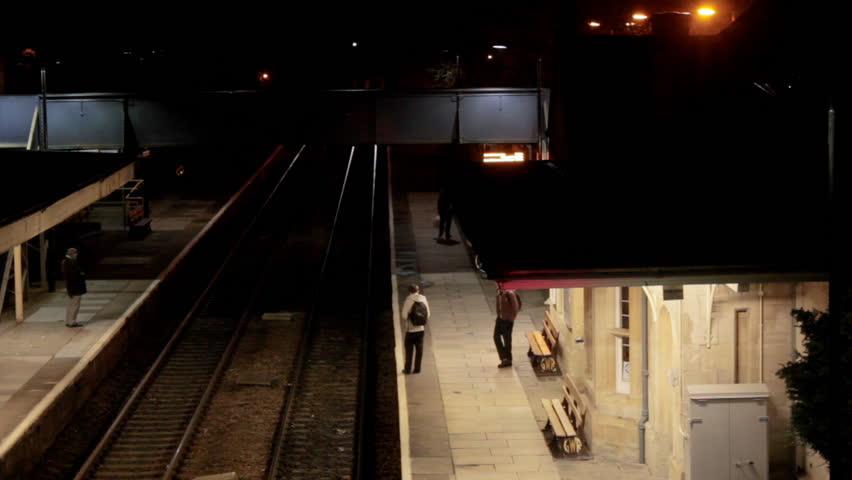 Train stopping at station at night, timelapse, 2