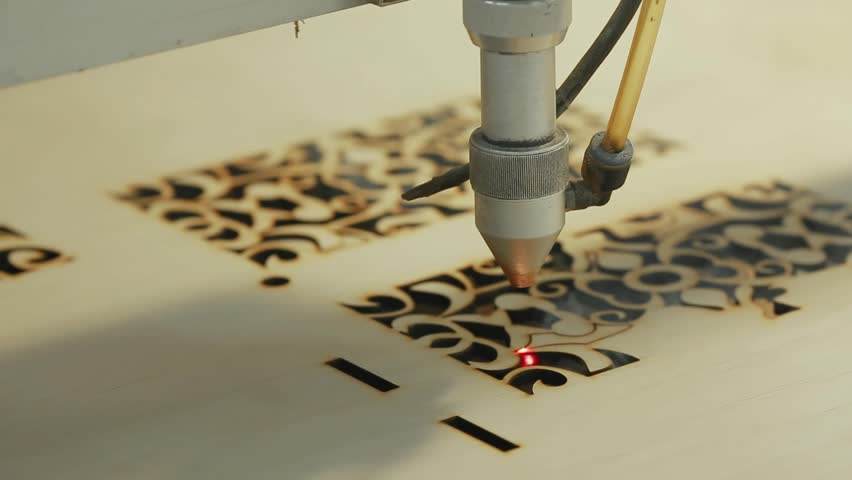 Machine for laser cutting wood close up cuts chipboard and the smoke appears. The red beam Royalty-Free Stock Footage #32674453