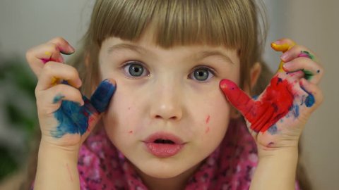 Close-up portrait of a girl. Girl hamming at camera. Girl covered in paint