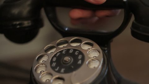 Close-up of a man's hand holds a receiver of an old telephone set