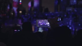 People taking video 3D mapping light show on a mobile phone. Hands of peoples taking photo to 3D mapping show on smartphone