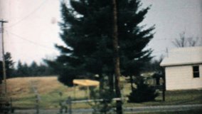 A left to right pan of an old house in the country in 1968.